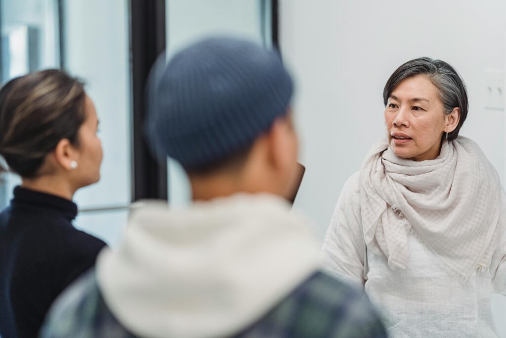 A group of adults engaged in a discussion in a modern indoor office environment.